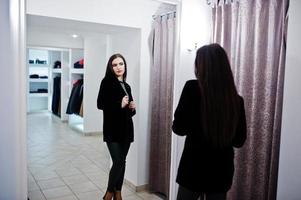 hermosa chica morena en la boutique de la tienda de ropa en ropa casual. foto