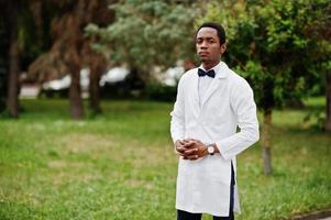 Stylish african american doctor with bow tie and lab coat posed outdoor. photo