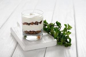 Dessert with mascarpone cheese and granola on a white wooden background. photo