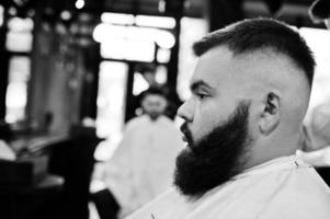 Handsome bearded man at the barbershop, barber at work. photo