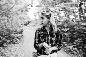 Portrait of an attractive blond girl posing with a compass in a forest. photo