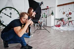 el equipo de dos fotógrafos disparando en el estudio. fotógrafo profesional en el trabajo. foto