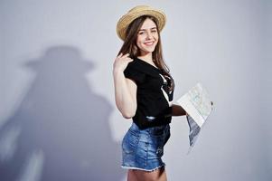 Girl tourist with map, wear in lol shirt, shorts and hat isolated on white. photo