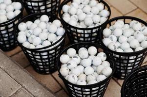 Golf balls in a baskets on pavement. photo