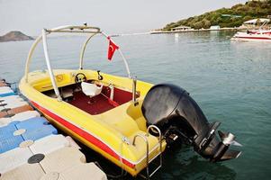 barco de motor amarillo en un mar azul tranquilo de bodrum, turquía. foto