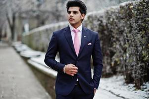 Elegant indian macho man model on suit and pink tie posed on winter day. photo