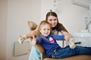 Little baby girl at dentist chair. Children dental. photo