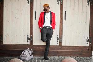 Fashion african american man model at red suit, with highlights hair and handbag posed at street. photo