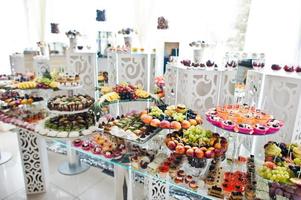 Beautiful wedding candy bar with sweets, fruits and food. Wedding banquet table photo