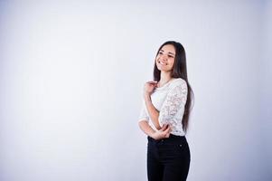 Portrait of an elegant young woman in white top and black pants in the studio. photo