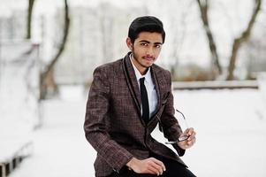 Stylish indian student man in suit and glasses posed at winter day outdoor. photo