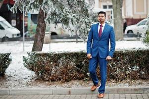 elegante modelo de hombre de moda indio en traje posado en el día de invierno. foto