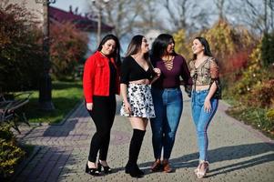 Group of four happy and pretty latino girls from Ecuador posed at street. photo