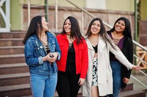 Group of four happy and pretty latino girls from Ecuador posed at street. photo