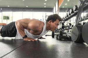 los hombres asiáticos hacen ejercicios haciendo seis o flexiones. concepto de fitness culturista asiático foto