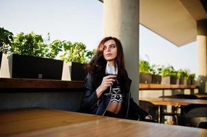 joven mujer rizada disfrutando de su vino en un bar. foto