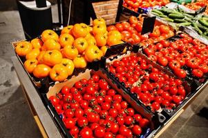 verduras de tomates rojos y amarillos en cajas en el supermercado. foto