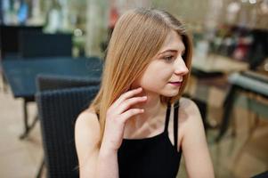 Close up portrait of blonde girl sitting on the mall. photo