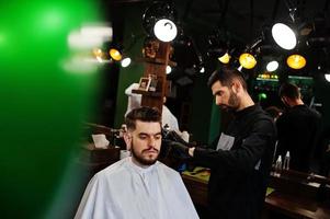 Handsome bearded man at the barbershop, barber at work. photo