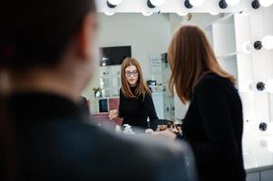 Make up artist work in her beauty visage studio salon. Woman applying by professional make up master. Beauty club concept. photo