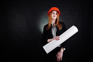 mujer ingeniera en casco de protección naranja con proyecto de papel de construcción. foto