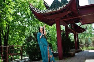 retrato de una hermosa brumette india o modelo de mujer hindú contra una casa tradicional japonesa. foto