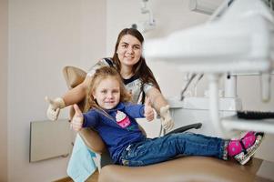 Little baby girl at dentist chair. Children dental. photo