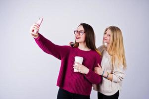 dos chicas con vestidos morados tomándose selfie en el estudio. foto