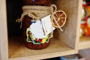 Glass jars with different kinds of jam and berries of a supermarket shelves or grocery store. Homemade canning products. Made with love. photo