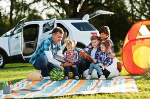 Family spending time together. Three kids. Outdoor picnic blanket. photo