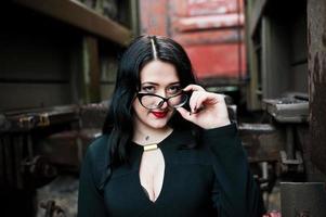 Brunette girl wear in black with glasses in railway station. photo