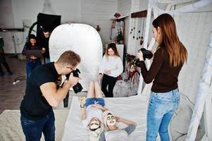 proceso de trabajo del equipo de fotógrafos, diseñadores y modelos en sesión fotográfica, clase magistral de profesionales. foto