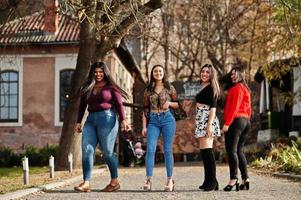 Group of four happy and pretty latino girls from Ecuador posed at street. photo