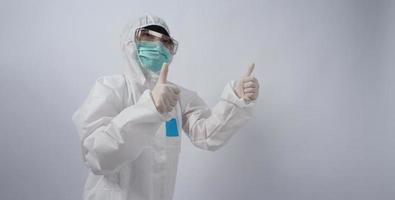 Doctor in PPE suit gesture make hand sign. Represent victory win over virus. photo