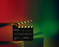 Crew hand holding plastic and wooden film slate board against camera. photo