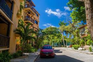 PLAYA DEL CARMEN, MEXICO - APR 2022 red Volkswagen Jetta VII 7 near the palms on a sunny day photo