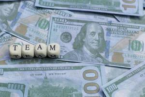 Team word on wood brick  background banknote. photo