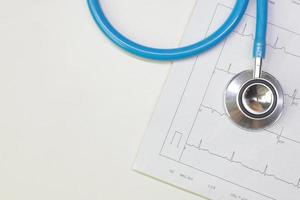 Blue stethoscopes and  Electrocardiography  chart close up image. photo