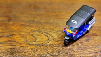 tuk tuk taxi  toy  on wood table close up image. photo