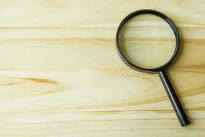 a  Magnifying glass on wood background image. photo