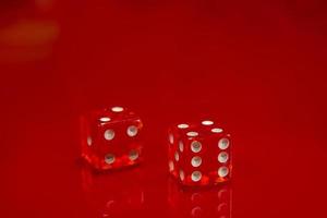 Two Red dice on bright red glossy background. photo