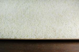 grano de arroz en la imagen de la mesa de madera para el fondo. foto