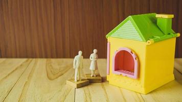 home toy  and white human figure on wood table for property, building content. photo