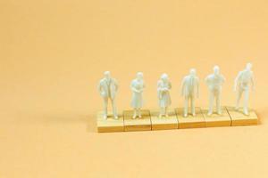 white  figure miniature on orange pastel for business content. photo