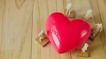 pink heart and white figure on wood table for Health, medical content. photo