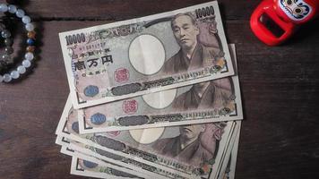 billete de yen en mesa de madera foto