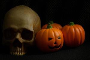 The halloween pumpkin jack and skull in black holiday background image. photo