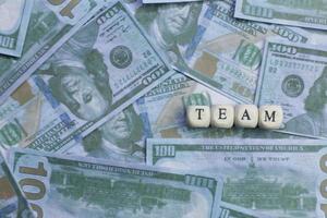 Team word on wood brick  background banknote. photo