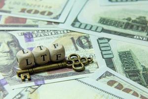 ltf  wooden cube and gold key on banknotes for business content. photo