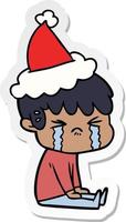 sticker cartoon of a boy crying wearing santa hat vector